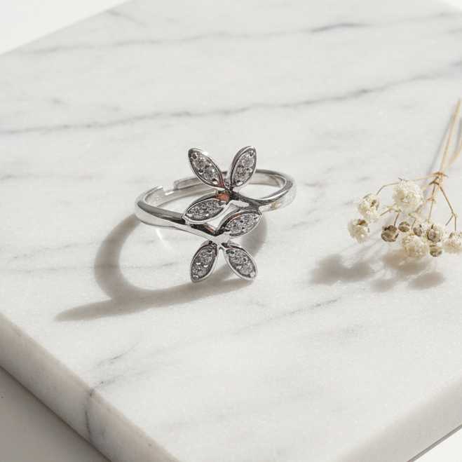 925 silver CZ floral ring flat lay on white marble surface with minimal props – luxury jewelry photography