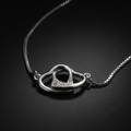 925 sterling silver free-moving interlocked open hearts necklace dramatic single-light studio shot on dark charcoal background – high contrast luxury fine jewelry editorial
