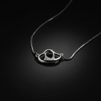 925 sterling silver free-moving interlocked open hearts necklace dramatic single-light studio shot on dark charcoal background – high contrast luxury fine jewelry editorial

