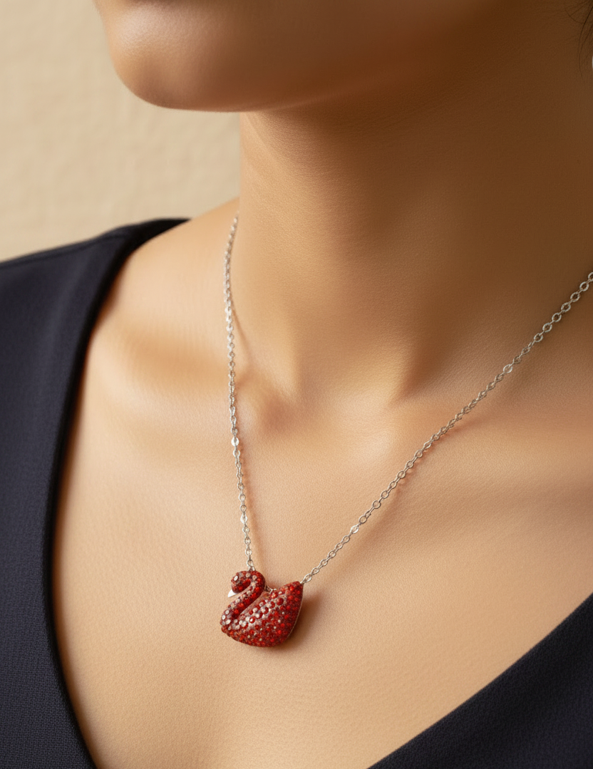925 silver red swan slider Necklace with a red heart pendant worn by a person against a neutral background in black dress.