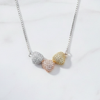 925 silver tri-tone pave hearts necklace by CHAKORE flat lay on white marble — Clara pendant India

