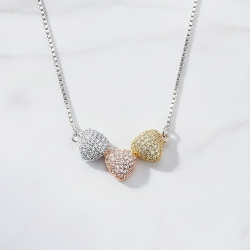 925 silver tri-tone pave hearts necklace by CHAKORE flat lay on white marble — Clara pendant India

