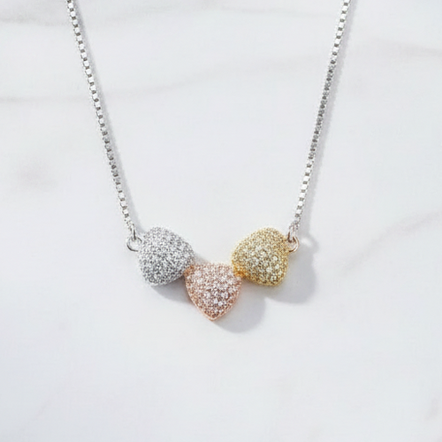 925 silver tri-tone pave hearts necklace by CHAKORE flat lay on white marble — Clara pendant India

