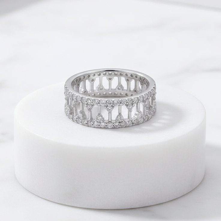 925 sterling silver wide band ring with open lattice design and pavé-set cubic zirconia stones – CHAKORE – Marble Flat Lay. Modern minimalist silver jewellery, architectural wide band ring, high-polish everyday wear.