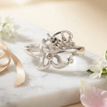 925 sterling Silver ring with floral design with matte finish on a marble surface with flowers and ribbon by CHAKORE
