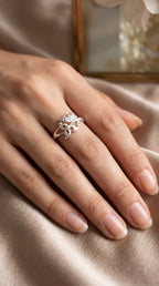 925 Sterling Silver Botanical Wrap ring by CHAKORE on hand wearing a silver ring with intricate design on a soft fabric background.