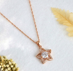 Rose gold star flower necklace with a cubic zirconia pendant on a white background