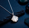 925 Sterling Silver necklace with a shell pendant on a dark stone surface