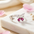 925 Sterling silver open butterfly ring by CHAKORE with  Butterfly-shaped ring with pink CZ on a marble surface with pink petals.