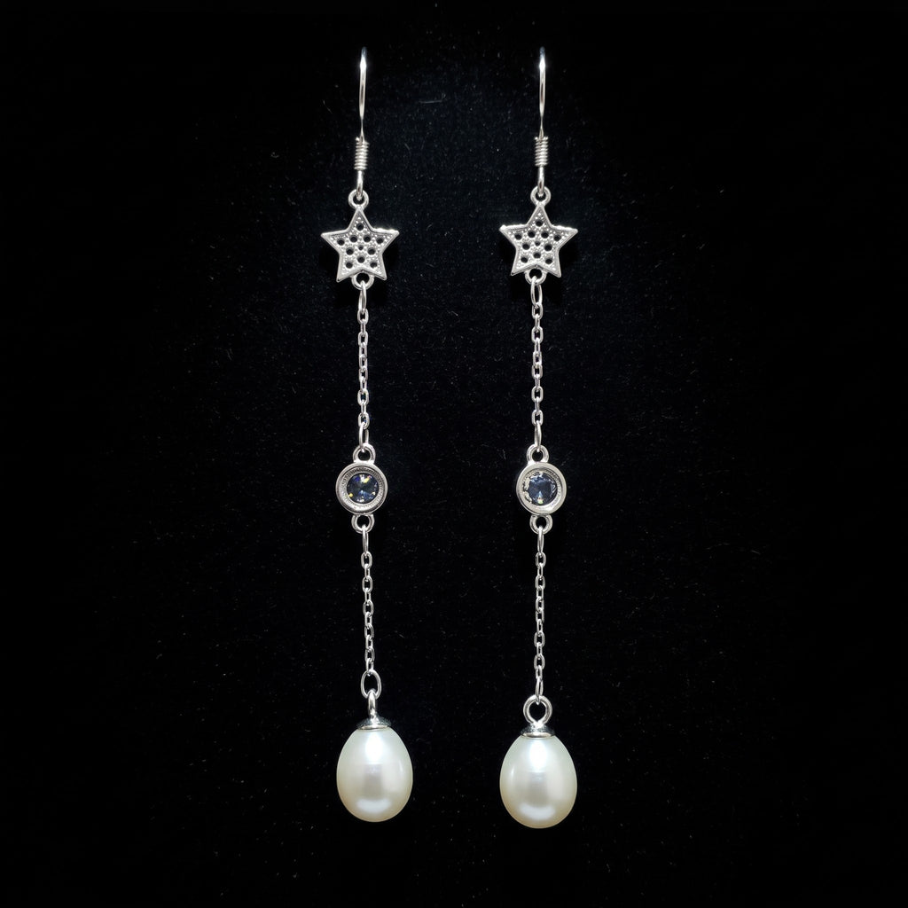 A pair of 925 sterling silver dangle earrings by Chakore with star-shaped charms, small round clear stones, and teardrop-shaped white pearls, displayed against a solid black background.