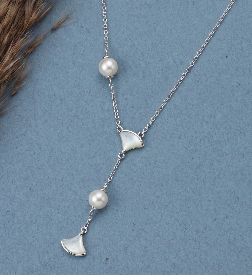 Asymmetric 925 silver Necklace by CHAKORE with pearls and GinkgoFan leaves pendants on a blue background