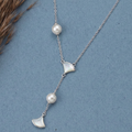 Asymmetric 925 silver Necklace by CHAKORE with pearls and GinkgoFan leaves pendants on a blue background