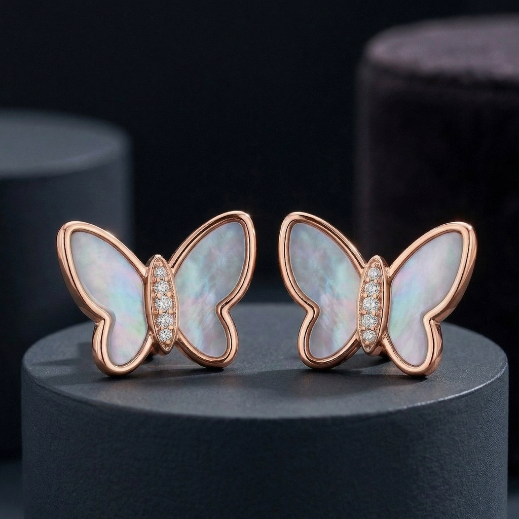 Butterfly shaped rose gold plated 925 silver with pearl and cubic zirconia  embedded jewellery placed on dark grey cylindrical stand.
