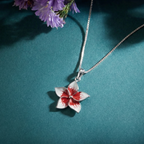 Flower-shaped pendant on a 925 silver chain against a teal background
