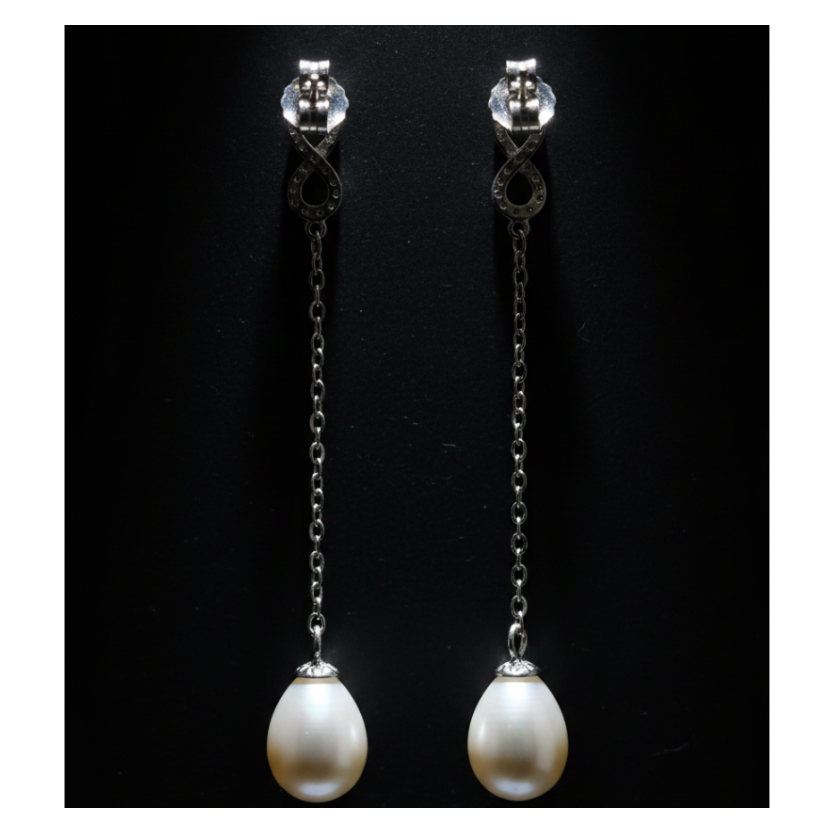 Back view of CHAKORE 925 sterling silver infinity earrings against black, showing butterfly backs, long chains and real freshwater pearl drops
