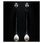 Back view of CHAKORE 925 sterling silver infinity earrings against black, showing butterfly backs, long chains and real freshwater pearl drops