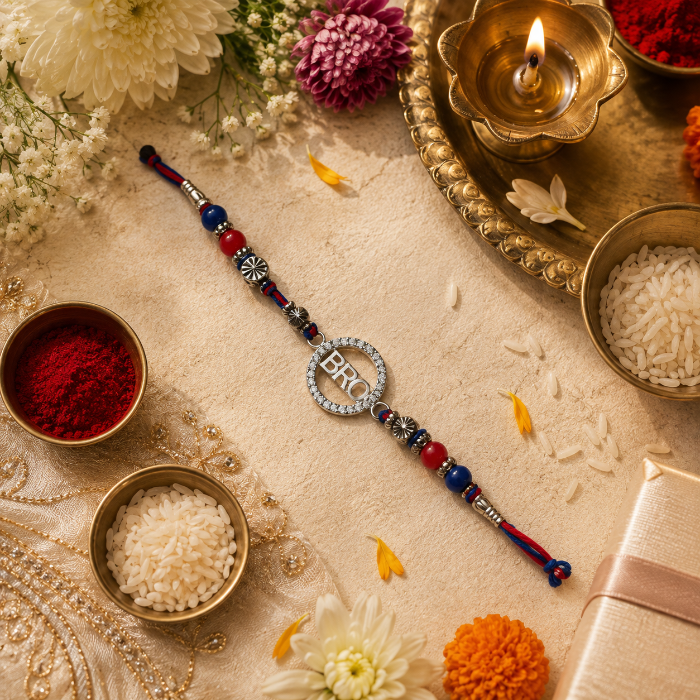 Chakore Bro Silver Rakhi featuring a genuine 925 sterling silver BRO pendant, styled in a festive Raksha Bandhan flatlay with roli, chawal, diya, marigold flowers and traditional decor.