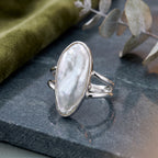 CHAKORE 925 sterling silver ring with a genuine baroque freshwater pearl and split-shank band on dark stone.
