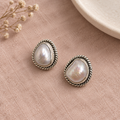 CHAKORE 925 sterling silver studs with genuine baroque freshwater pearls and rope borders on blush linen.