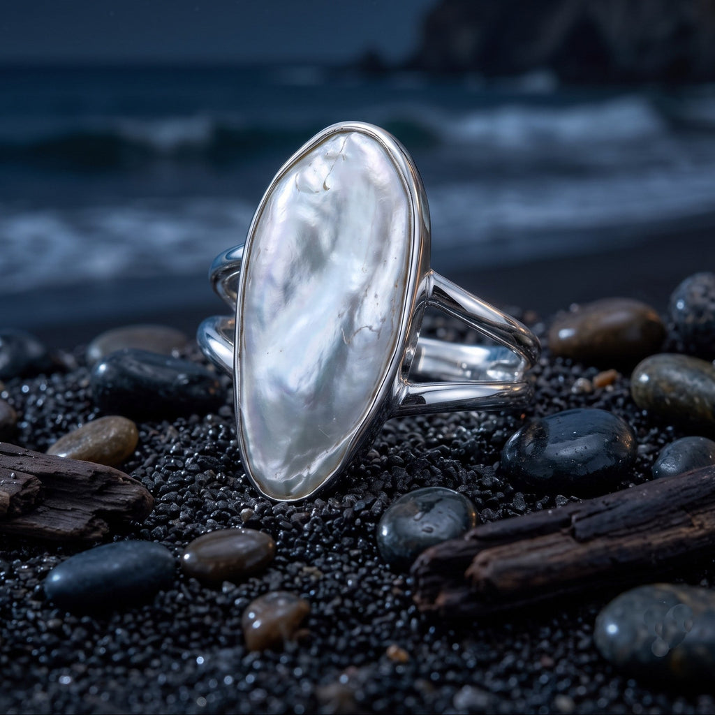 CHAKORE authentic baroque freshwater pearl ring in 925 sterling silver, displayed on black sand and pebbles.