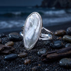 CHAKORE authentic baroque freshwater pearl ring in 925 sterling silver, displayed on black sand and pebbles.