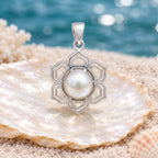 CHAKORE genuine freshwater pearl lotus pendant in 925 sterling silver, displayed on a shell with an ocean backdrop.
