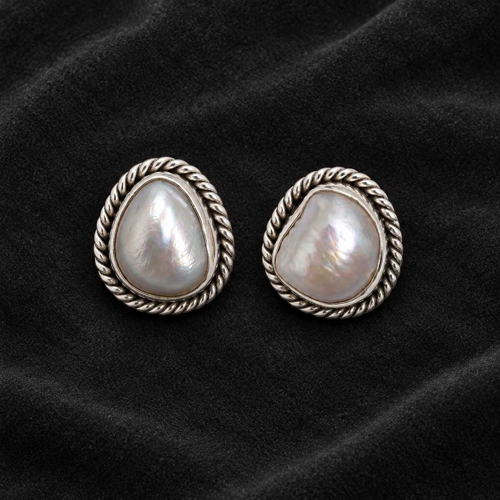 CHAKORE genuine freshwater pearl stud earrings with oxidized 925 sterling silver rope borders on charcoal velvet.