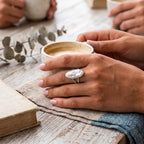 CHAKORE silver jewellery's hypoallergenic 925 sterling silver freshwater pearl ring worn on a hand holding a ceramic coffee cup.