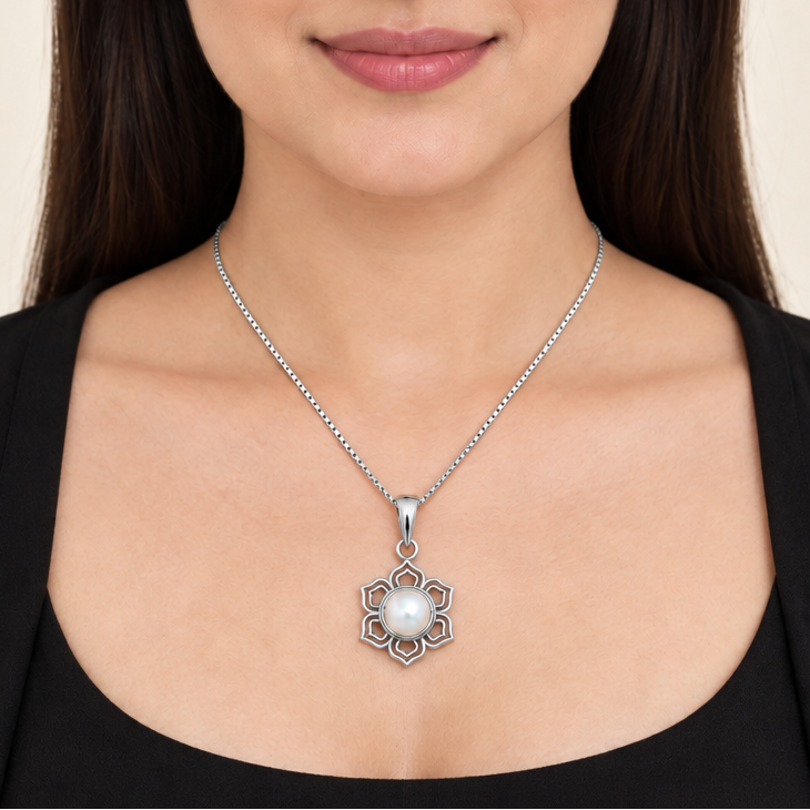 CHAKORE 925 sterling silver lotus pendant with a real freshwater pearl, worn on a chain with a black outfit.