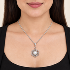 CHAKORE 925 sterling silver lotus pendant with a real freshwater pearl, worn on a chain with a black outfit.
