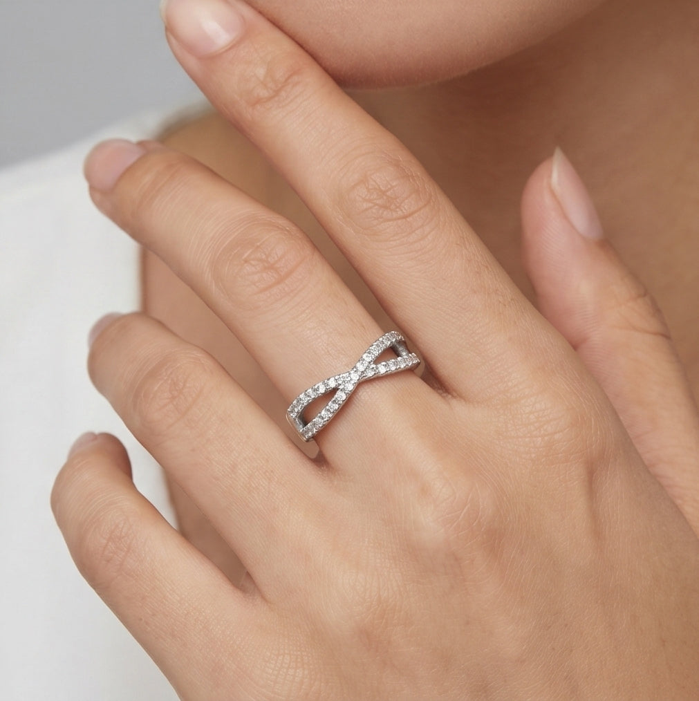 Crossover Infinity 925 Sterling Silver Ring by CHAKORE with Pavé Cubic Zirconia – Adjustable Band Silver ring on a hand with a neutral background