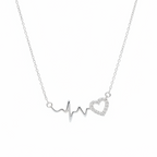 A delicate silver necklace featuring an EKG heartbeat line design with one open heart and one filled heart, both adorned with small clear stones, suspended from a fine silver chain against a plain white background.