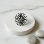 Oxidised 925 silver filigree flower ring on minimal white elevated platform, marble background, handcrafted twisted wire cocktail ring
