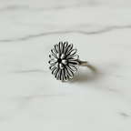 Oxidised sterling silver filigree flower ring at 45 degree angle showing face and band, handcrafted twisted wire detail, white background