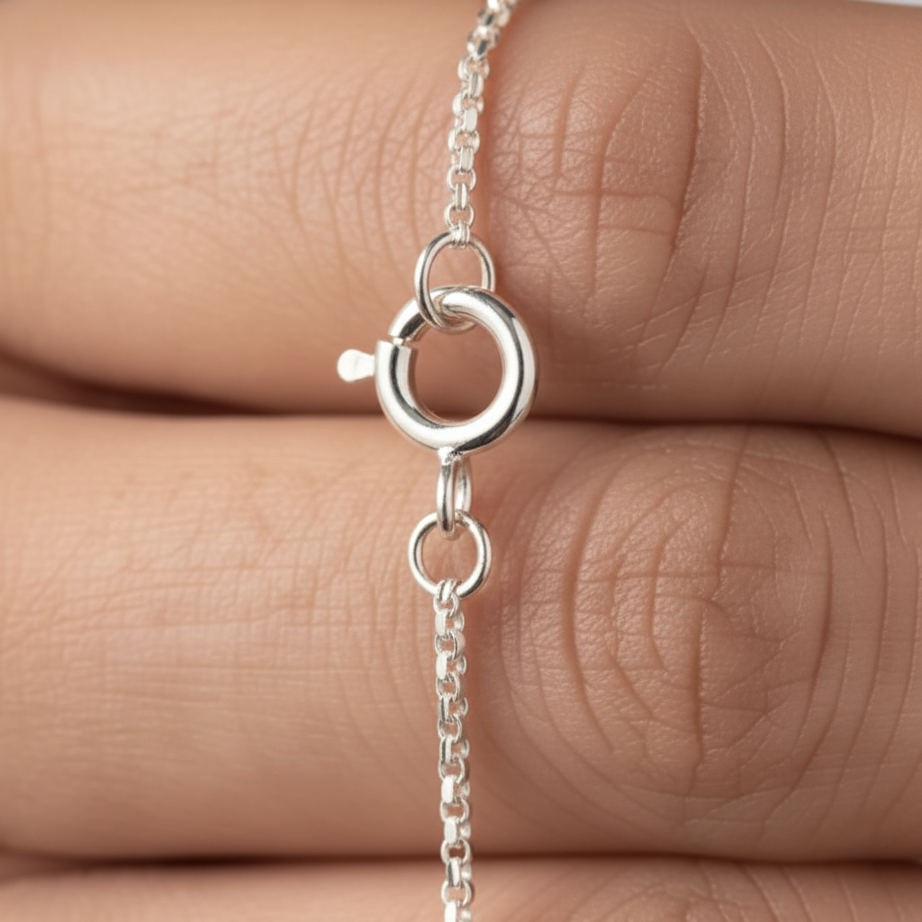 A close-up of a 925 sterling silver jewellery chain by CHAKORE with a spring-ring clasp being held against a person's fingers to show scale.
