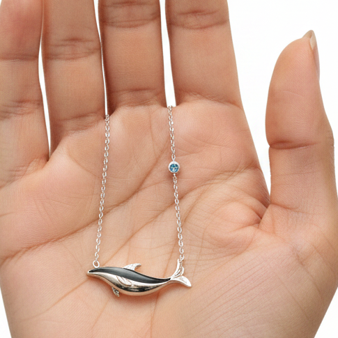 Silver Whale Necklace Resting on Female Model Palm