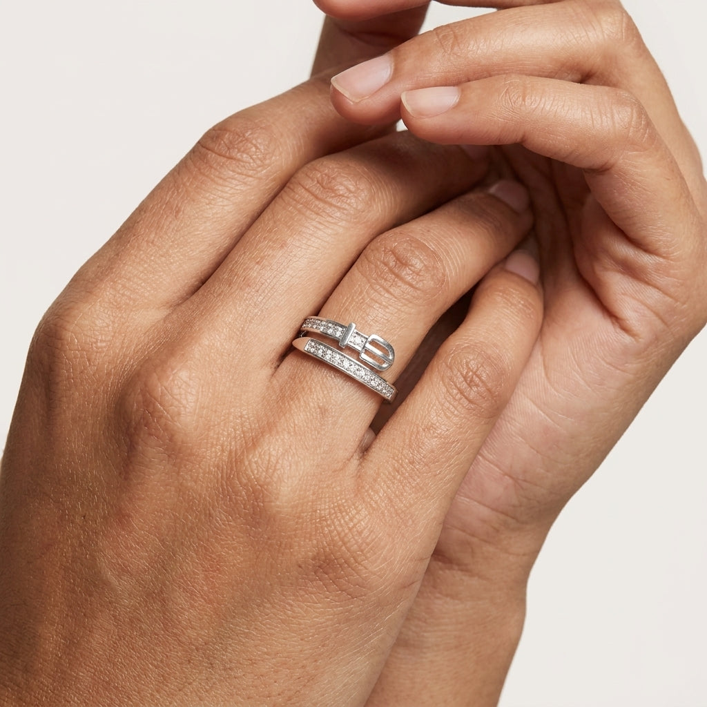 Close-up of a hand wearing a trendy belt 925 silver ring by CHAKORE with a diamond on a light background