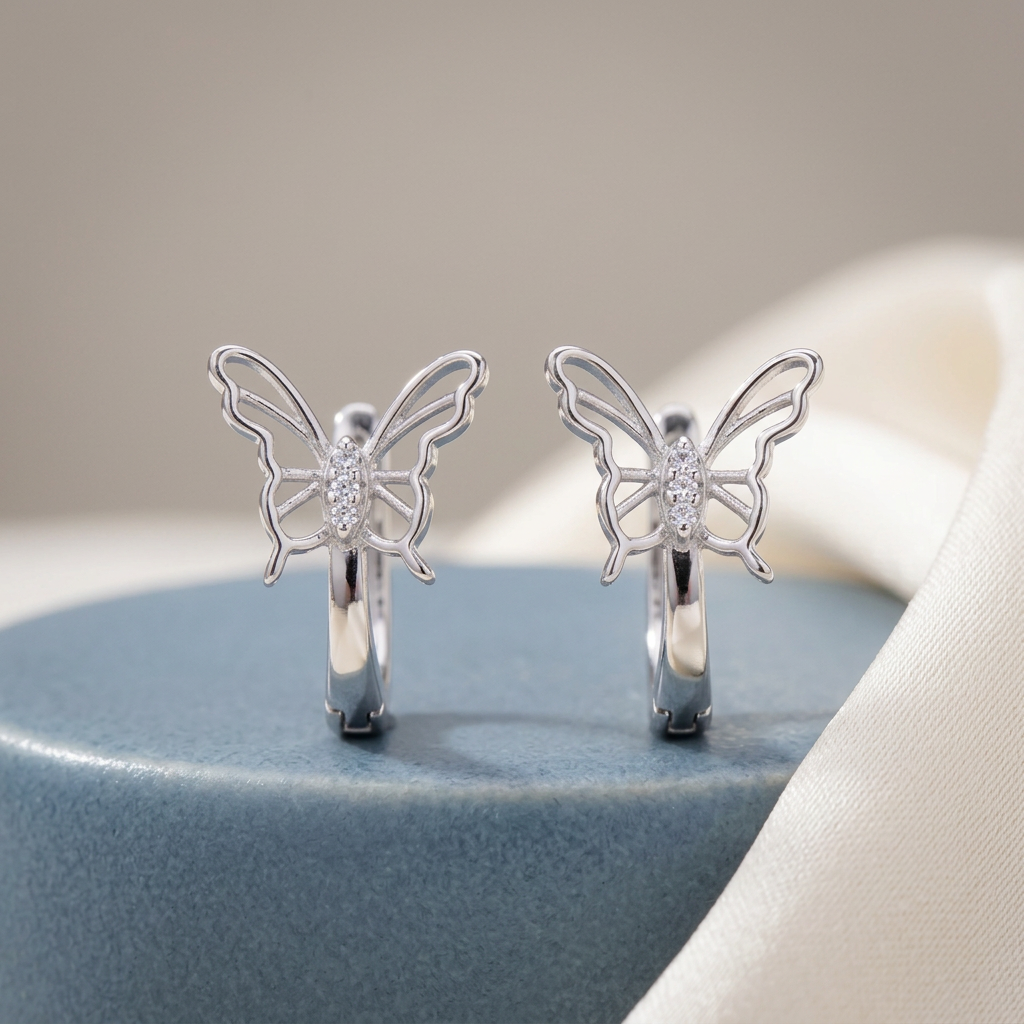 Winged Sparkle hoops on a blue ceramic display