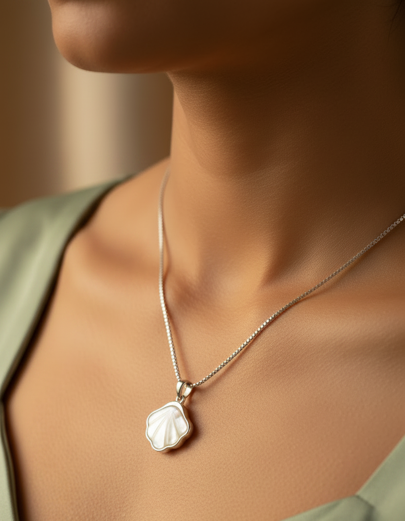 925 Silver Coastal shell pendant worn at neckline of a model wearing sage green dress.